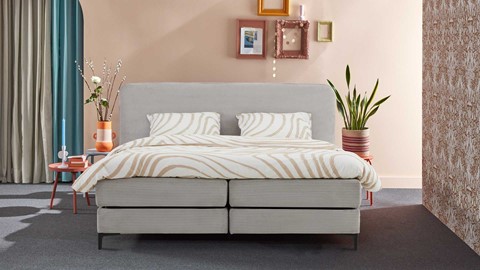 Grijze boxspring met ribstof in slaapkamer