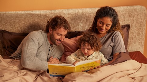 Gezin leest een boek op bed