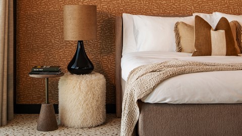 een bed met een zwarte lamp erop