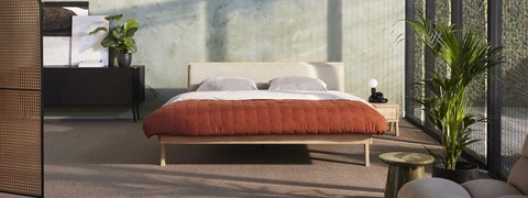 een bed met een rode deken en kussens