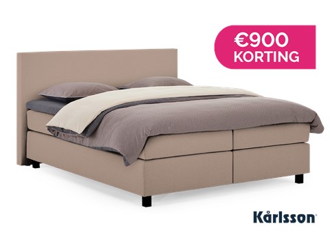 een bed met een roze en witte hoes