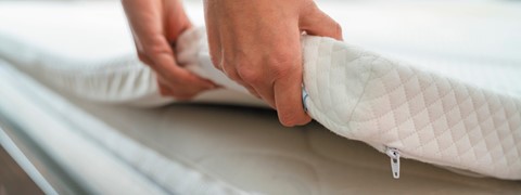 een persoon die een matras opvouwt