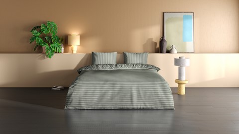 een bed met kussens en een plant in een kamer