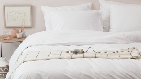 koptelefoon op een deken op een bed