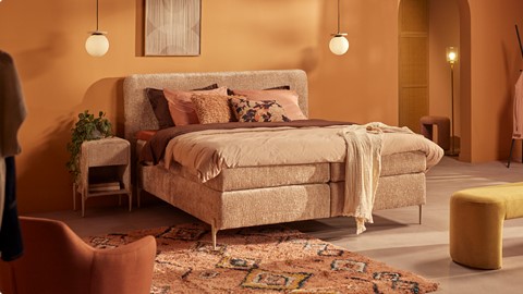 een bed met kussens en een tapijt in een kamer