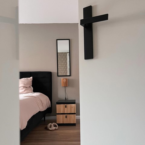 een slaapkamer met een bed en een spiegel