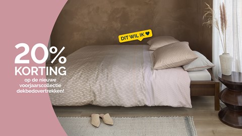 Een bed met kussens en schoenen op de vloer