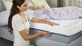 Een vrouw die op een bed zit