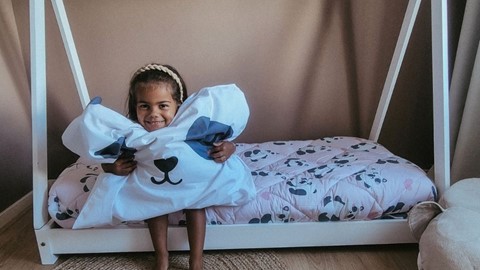 Een meisje dat een hoofdkussen houdt