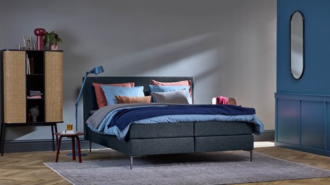 een bed met een blauw en roze beddengoed
