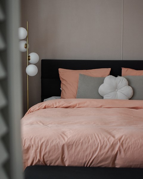 Een bed met roze lakens en kussens