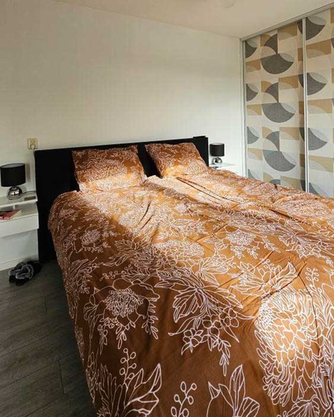 een bed met een bruin dekbed en kussens