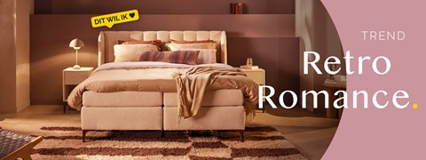 een bed met kussens en een tapijt in een kamer