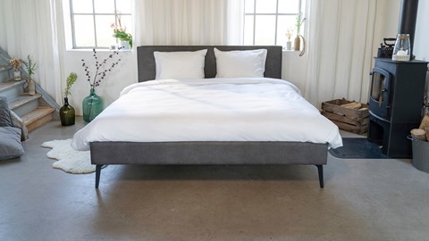 een bed met witte lakens en kussens