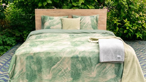 een bed met een deken en kussens