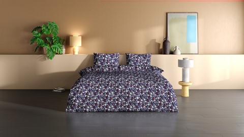 een bed met gebloemd beddengoed en kussens