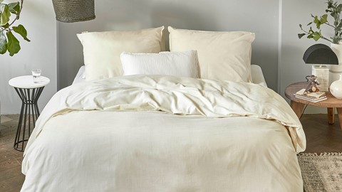 een bed met witte lakens en kussens