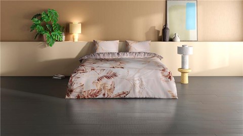 een bed met kussens en een plant in een kamer