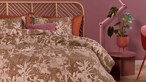 een bed met een plant op de achtergrond
