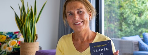 Een vrouw die naar de camera glimlacht