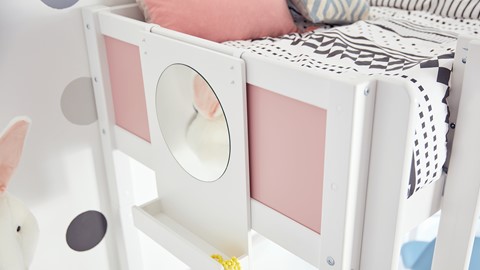 een wit bed met roze en zwarte kussens