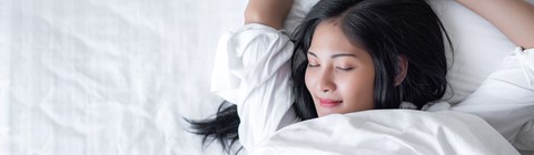 een vrouw die in bed ligt met haar ogen gesloten