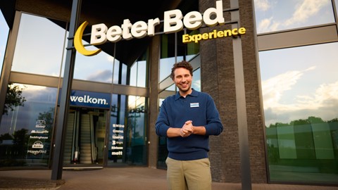 Een man die voor een gebouw staat