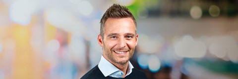 Een man die glimlacht voor een foto