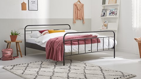 een bed met een roze deken