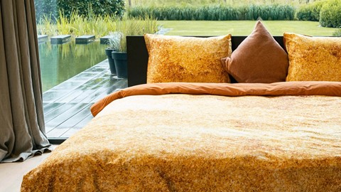 een bed met kussens en een houten terras