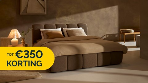 Een bed met een bruin bedframe