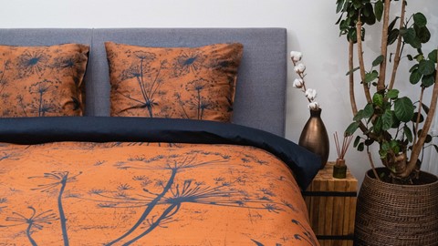 een bed met een kussen en een vaas van katoen