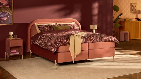 Een bed met een rood beddengoed