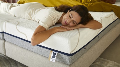 Een vrouw die op een matras slaapt