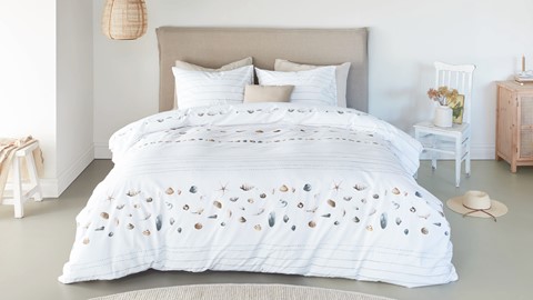 een bed met een wit dekbed en kussens