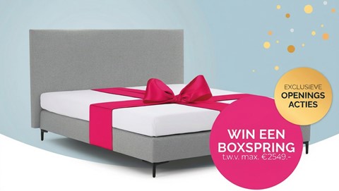 Een bed met een roze strik