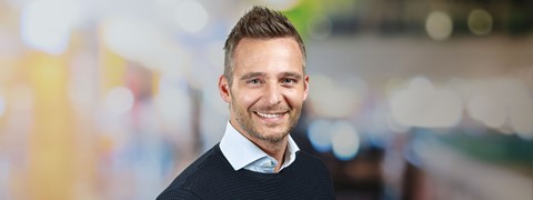 een man die glimlacht voor een foto