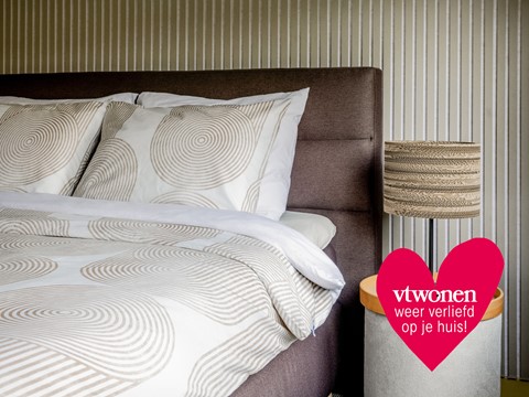 een bed met kussens en een lamp