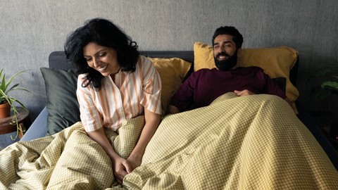 Een man en een vrouw die in bed zitten