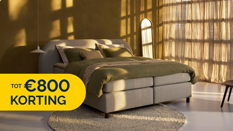 een bed in een kamer met een rond kleed en een raam