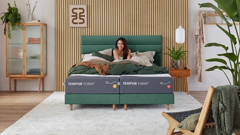 Een vrouw die op een bed zit