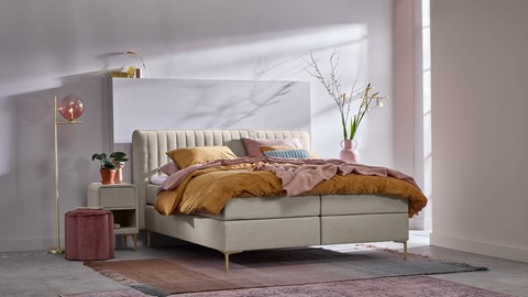 Beige boxspring in slaapkamer