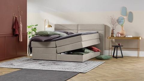 Beige boxspring met opbergruimte in slaapkamer