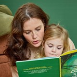 Een vrouw en een kind die een boek lezen