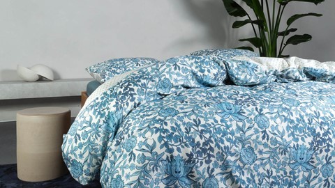 een bed met een blauw-wit bloemendekbed