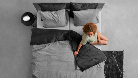 Een vrouw die op een bed zit