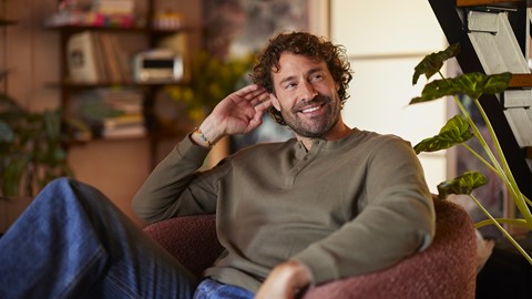 Een man die in een stoel zit