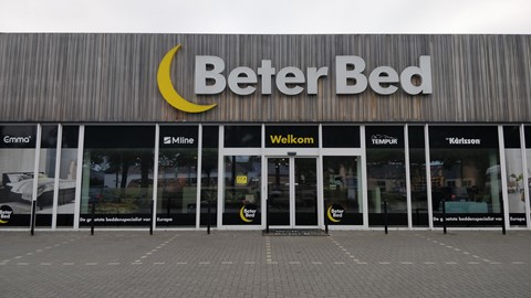 een gebouw met glazen deuren en een uithangbord