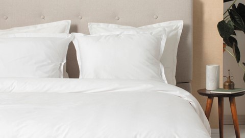 een bed met witte kussens